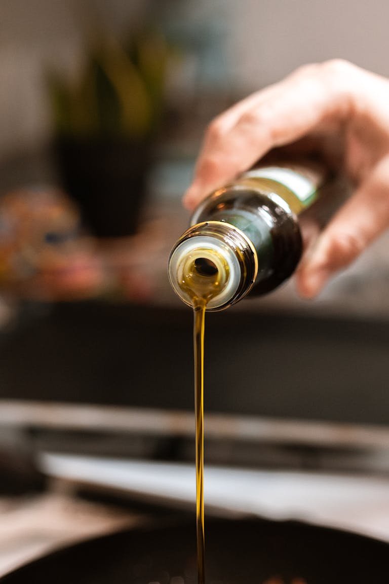 A close-up shot of truffle oil being poured into a pan, highlighting healthy cooking.