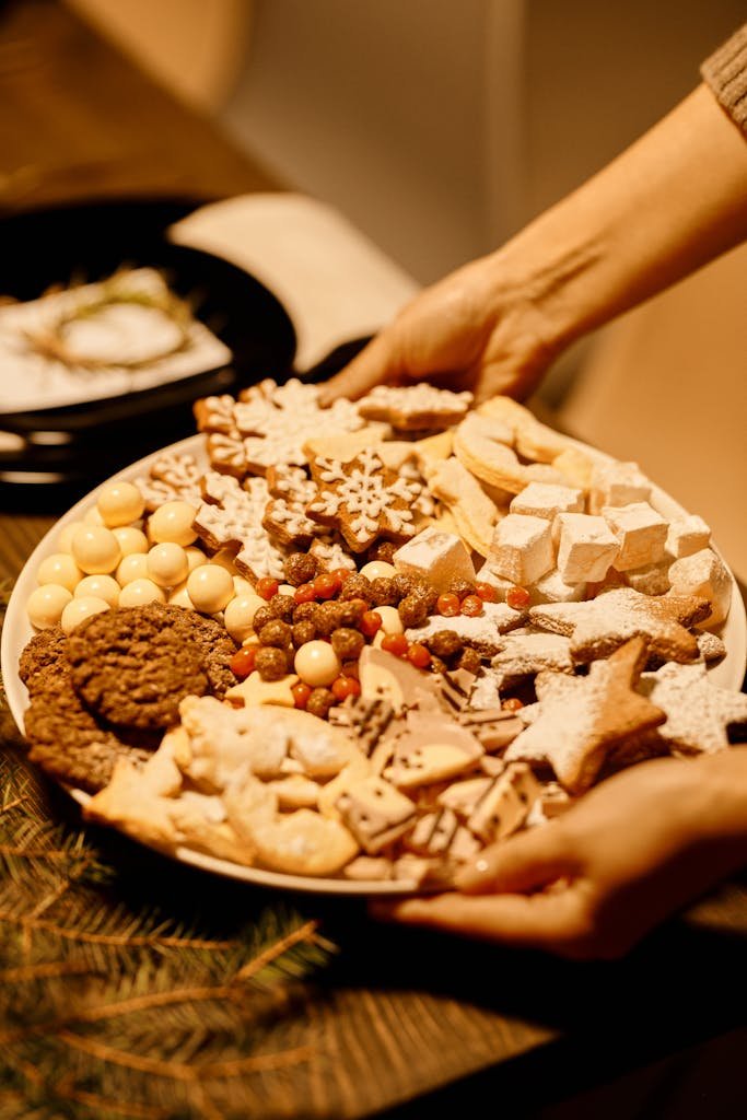 A Christmas party platters with various holiday cookies being served at a Christmas gathering.