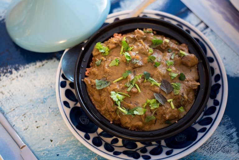 An traditional african cuisine of savory Moroccan tagine garnished with fresh herbs, served in a traditional dish.