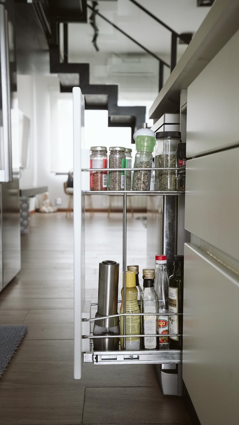 A sleek modern kitchen with a pull-out spice and oil storage drawer.