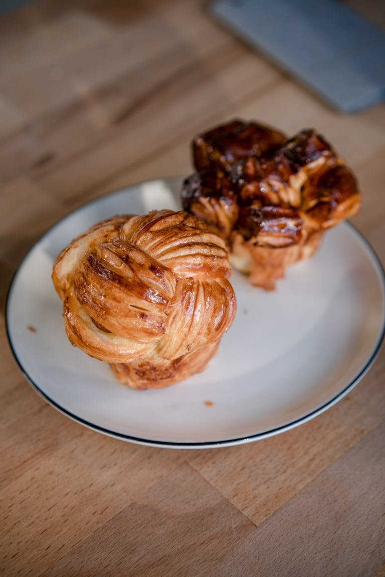 Close-up of homemade Danish pastries on a plate showcasing their intricate patterns.