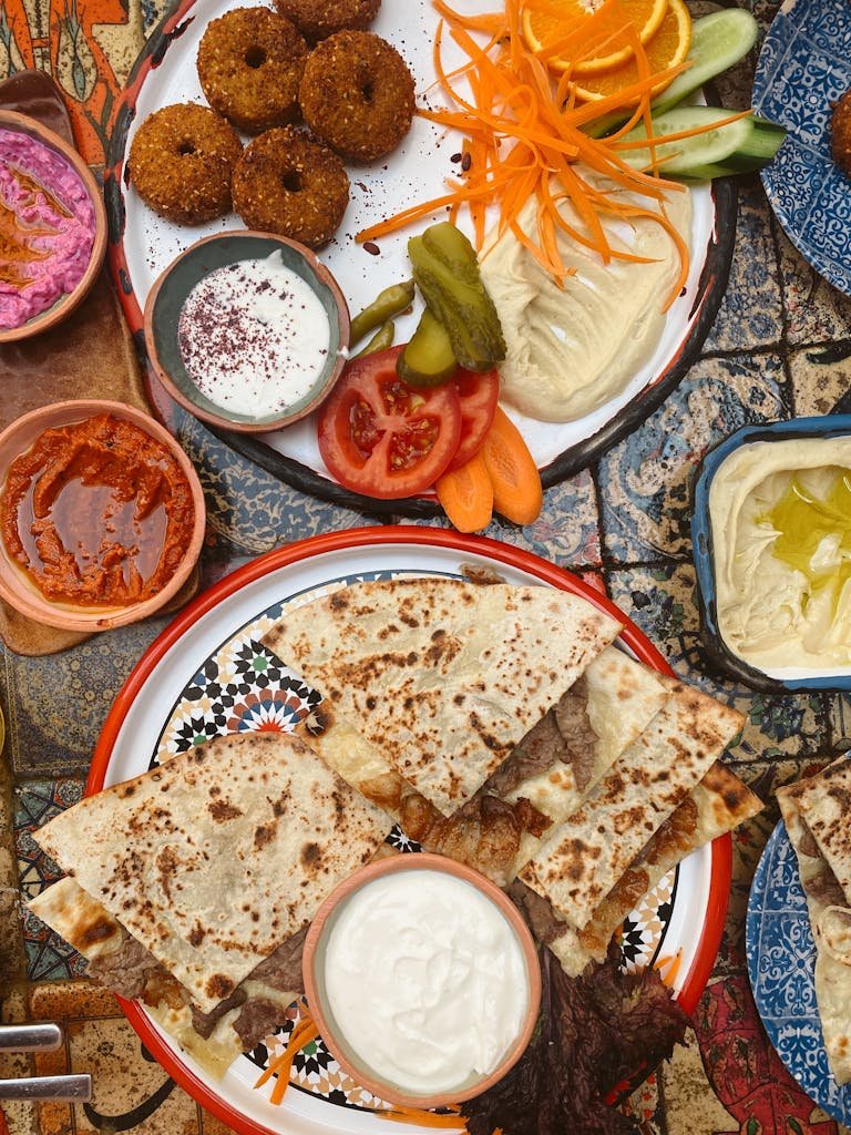 Colorful and diverse authentic Lebanese mezze platter featuring fresh vegetables, dips, and flatbread.