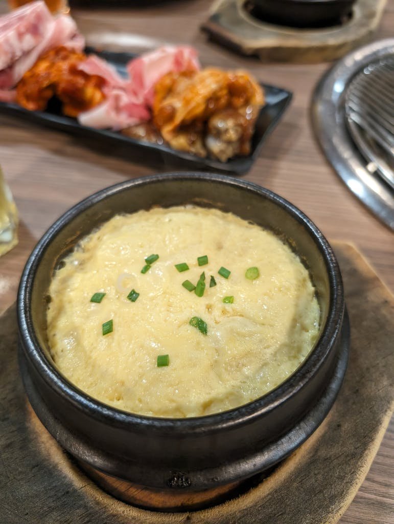 Savory Korean steamed egg served in a traditional hot stone bowl, perfect for a hearty meal.