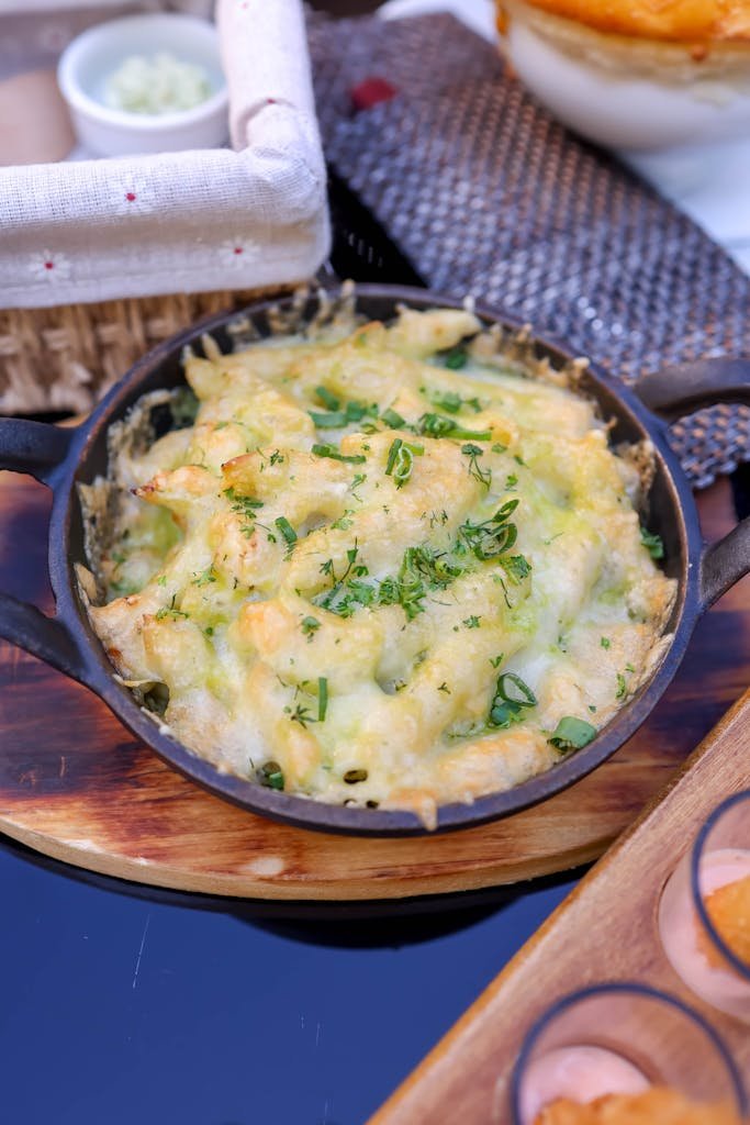 Delicious homemade one pot meal of baked macaroni and cheese topped with melted cheese and herbs, ideal for comfort food lovers.