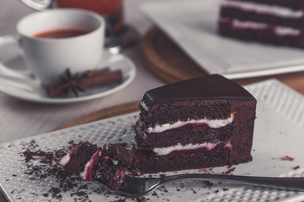 Indulgent black forest cake slice paired with a warm cup of coffee, perfect dessert setting.