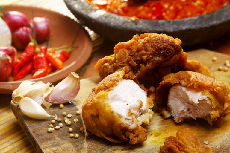 Delicious crispy fried chicken served with fresh garlic and chili peppers. Perfect for a flavourful meal.