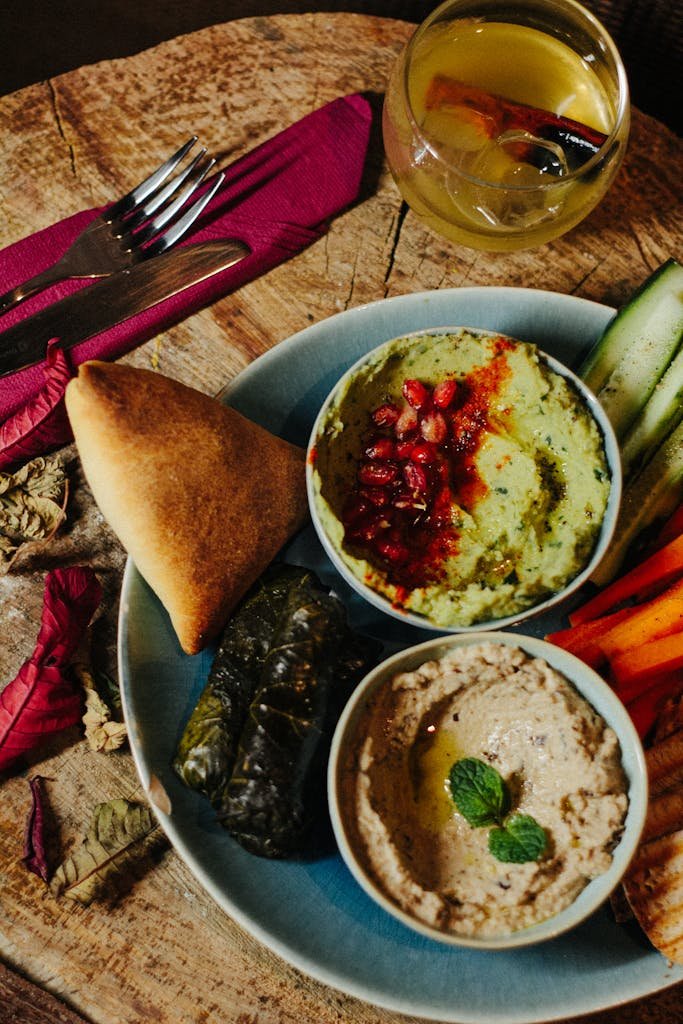 Colorful Middle Eastern mezze platter featuring hummus, baba ganoush, pita, and fresh vegetables.