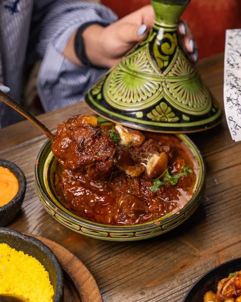 Showcasing world cuisines with an Authentic Moroccan lamb tagine served hot in a traditional dish. Perfect blend of flavors.