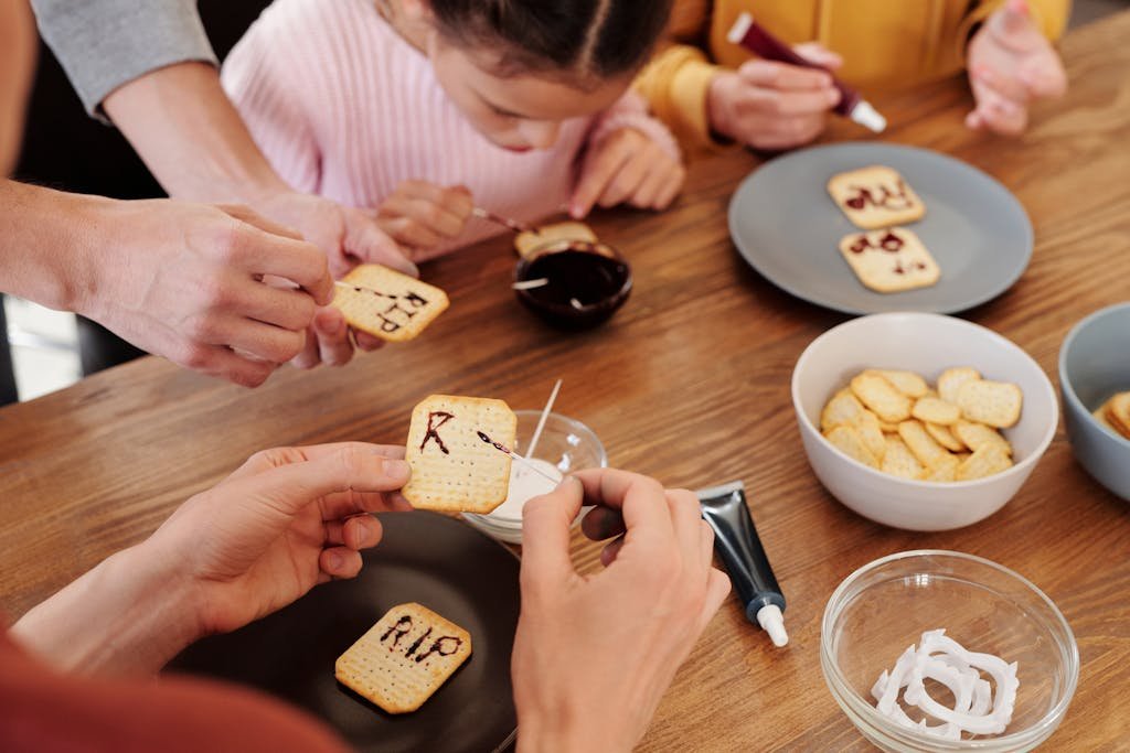 A family enjoys baking and decorating Halloween-themed cookies together indoors.