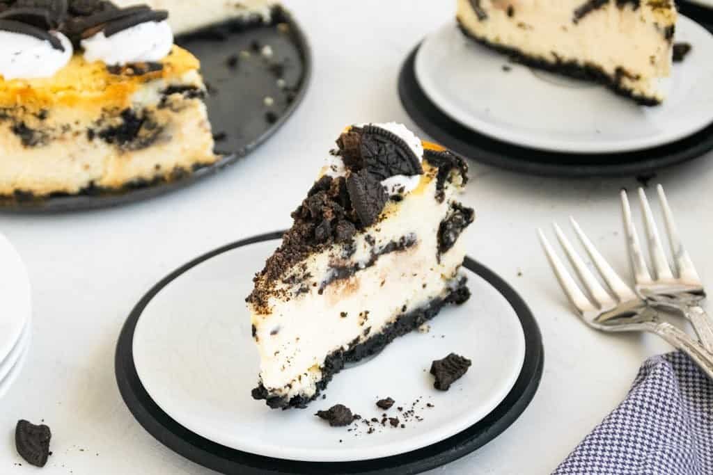 Close-up of a sliced Oreo cheesecake on a ceramic plate, perfect for dessert enthusiasts.