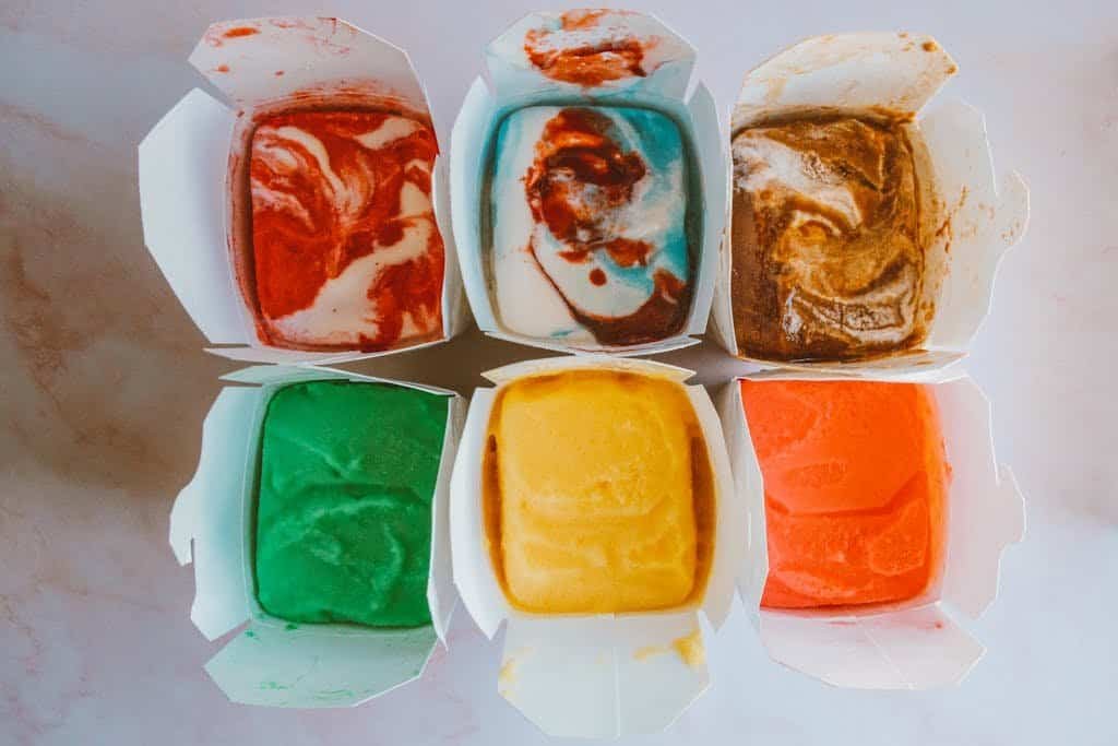Vibrant ice cream scoops in takeout boxes showcasing a variety of flavors.