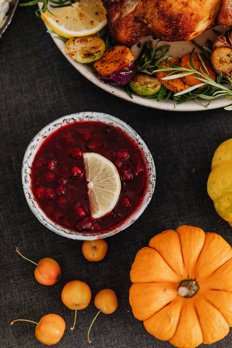 Autumnal still life with cranberry sauce, pumpkins, and seasonal vegetables for a thanksgiving meal.