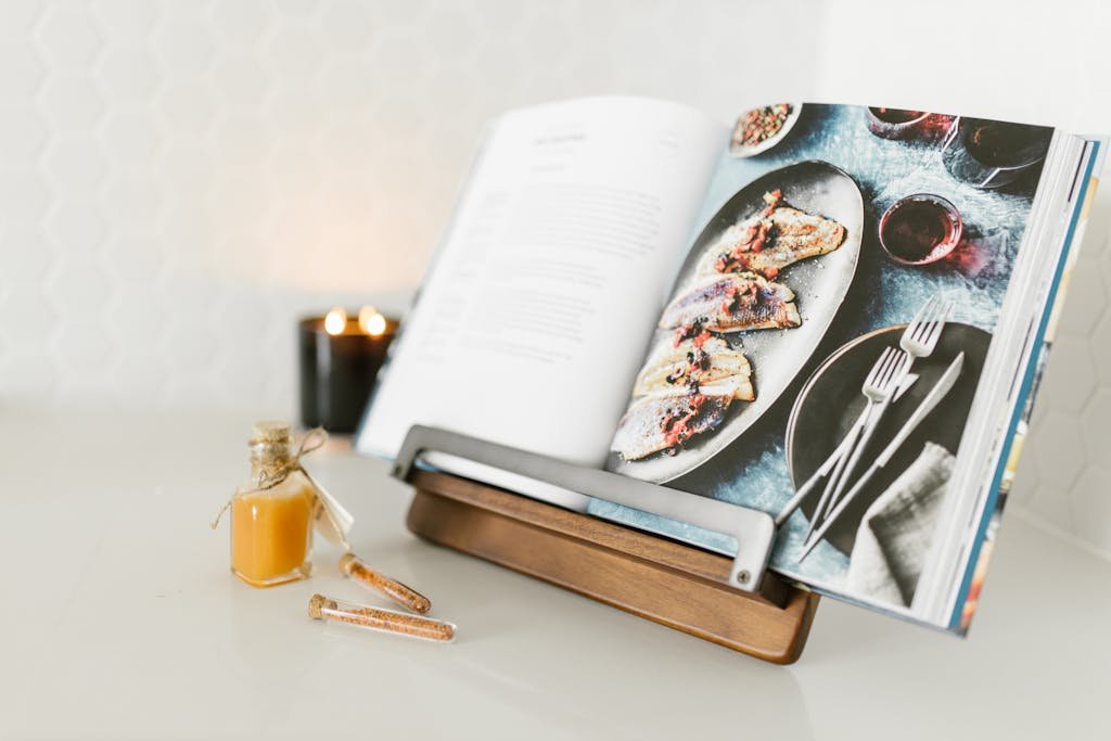 Open cookbook with a delicious fish recipe, styled with candlelight ambience showcasing one of the best cookbooks on Amazon.
