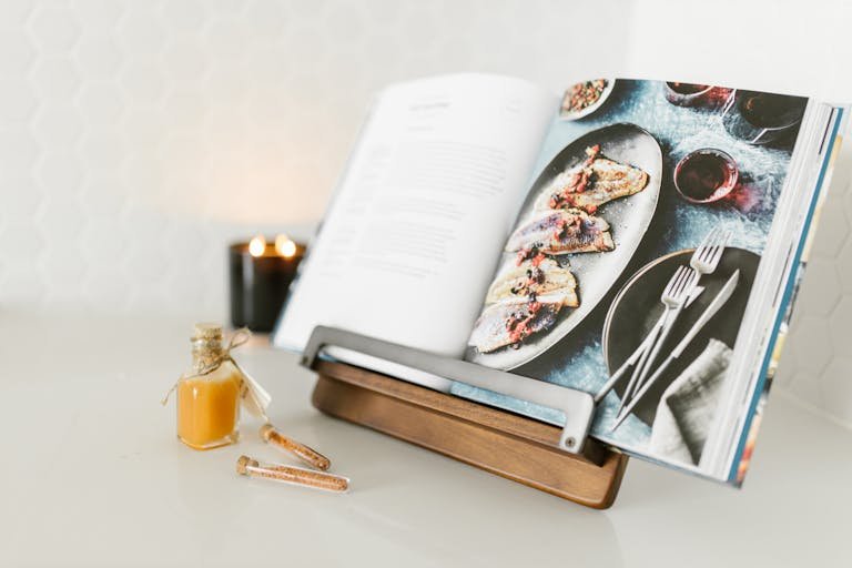 Open cookbook with a delicious fish recipe, styled with candlelight ambience showcasing one of the best cookbooks on Amazon.