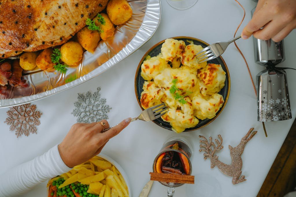 Top-down view of a holiday feast featuring roast turkey, potatoes, and festive table decor.