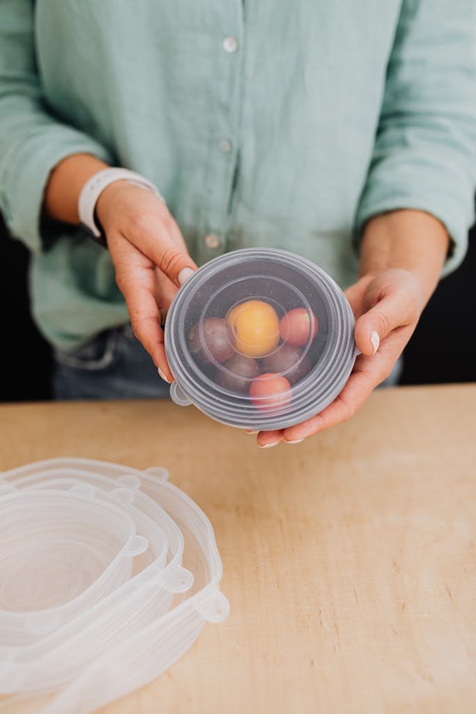 Close-up of a woman holding a silicone food cover with fruits, emphasizing eco-friendly kitchen storage.