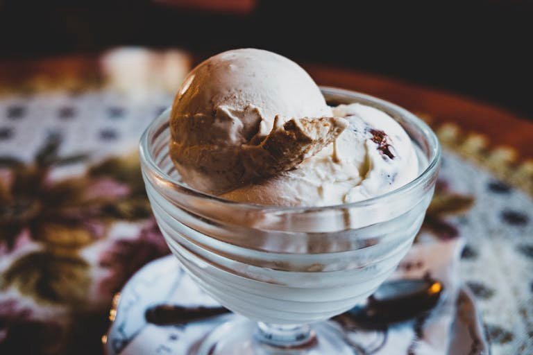Delicious vanilla ice cream in a glass bowl, perfect for dessert indulgence.