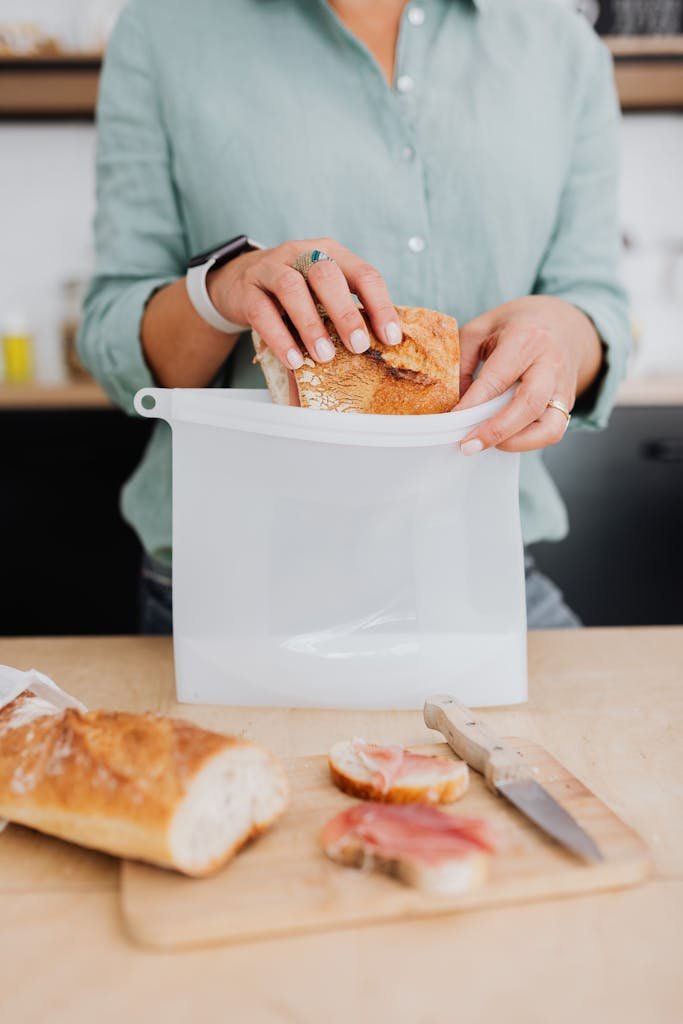 Woman storing baguette in eco-friendly silicone bag promoting zero waste lifestyle.