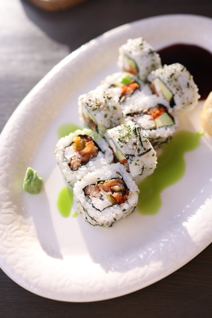 Close-up of sushi rolls with salmon and avocado on a white plate made using a sushi making kit.