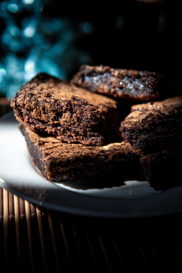 Close-up shot of rich, fudgy chocolate brownies on a white plate, perfect for dessert cravings.
